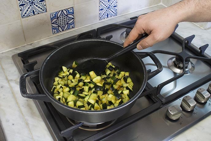 In una casseruola capiente, riscaldate un filo d'olio e cuocete per una decina di minuti le zucchine tagliate a cubetti piccoli, aggiustando di sale e pepe secondo i vostri gusti. Cotte le zucchine, mettele da parte. 